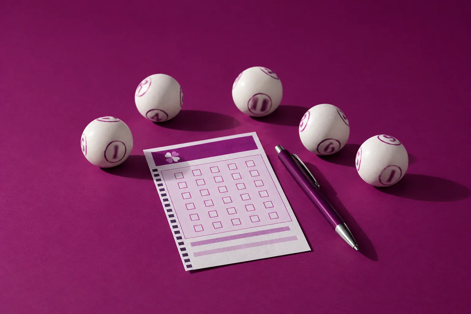 Volante da Loto Fácil, caneta e bolas sobre uma mesa de estúdio, com o jogo marcado à espera do próximo sorteio.